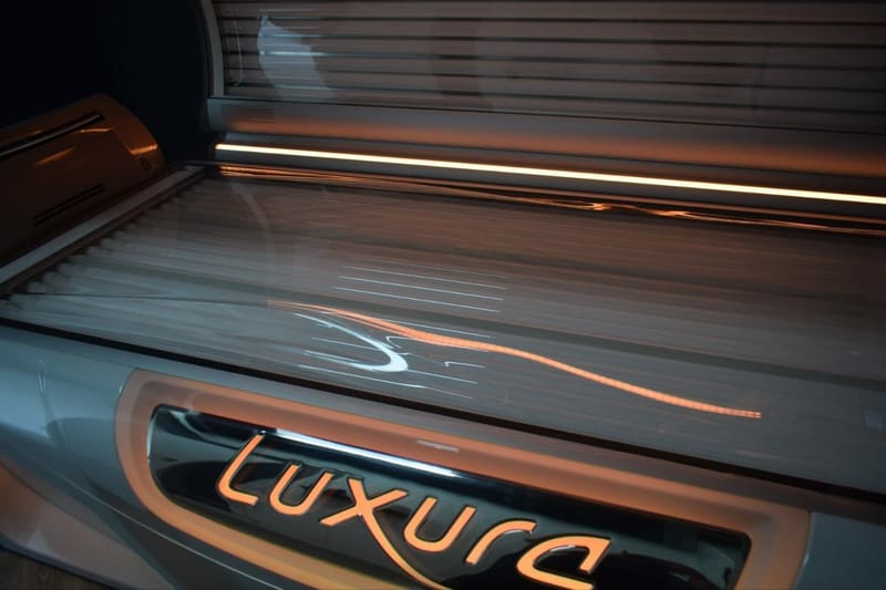 Luxura sunbed with its lid open and warm light along the edge
